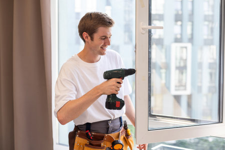 Worker installing plastic window indoors, closeup viewの写真素材