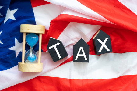 USA flag, gavel and wooden cubes with letters TAX. Tax fraud concept.