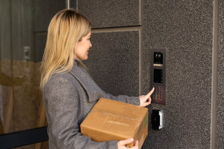 Woman locking smartlock on the entrance door using a smart phone. Concept of using smart electronic...