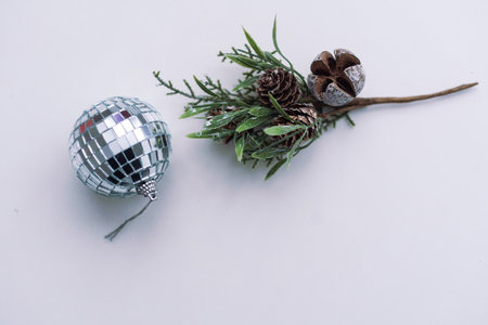 New Year background. Golden pine cones, fir branch, Christmas ball on white background. Top view, space for text.の写真素材