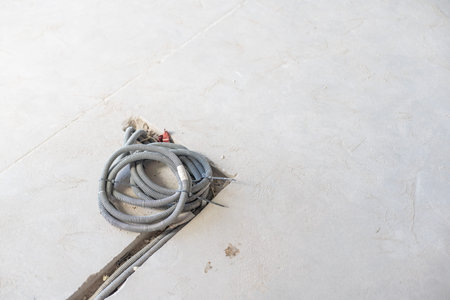 Rope hoist lifting steel frame with cement wall in the room
