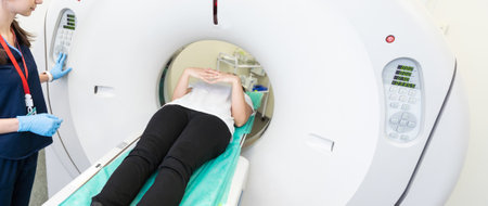 beautiful woman lying on ct scanner bed during tomography test in hospitalの写真素材
