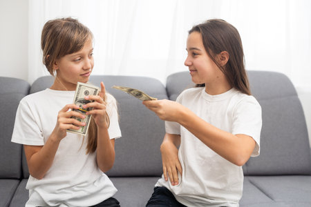 Photo of lucky caucasian girls wearing casual clothing holding fans of dollars in handsの写真素材