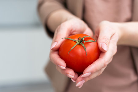 woman showing fresh tomatoes from organic farming.の写真素材