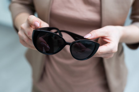 Hand holding sunglass in optical shop, close-up of sunglass in handの写真素材