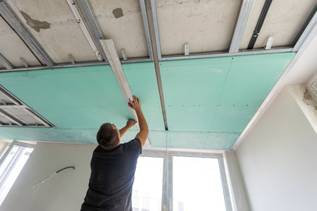 Drywall Installers. Men holding a gypsum board figured cutの写真素材