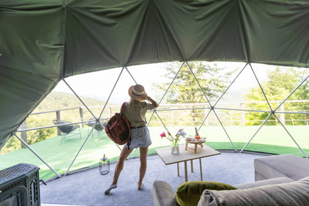 Transparent bubble tent at glamping, Lush forest around and interior. woman resting in glampingの写真素材