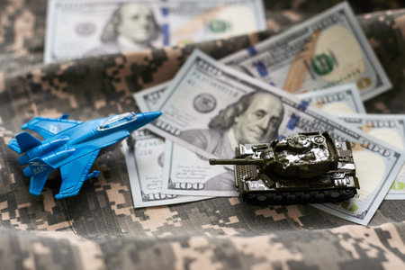 Toy fighter. Airplane model on dollars background.