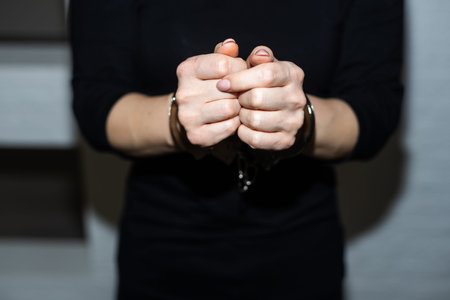 prisoner woman, prisoners hands are handcuffed behind her back.