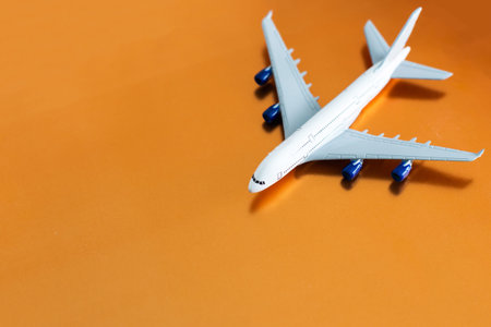 Airplane on orange background, flat lay, travel concept