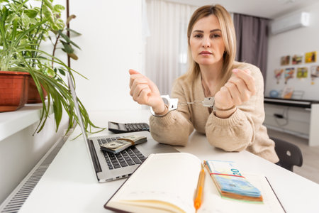 Woman hand and us dollar banknotes in steel handcuffs suggesting corruption or evasion conviction concept.の写真素材
