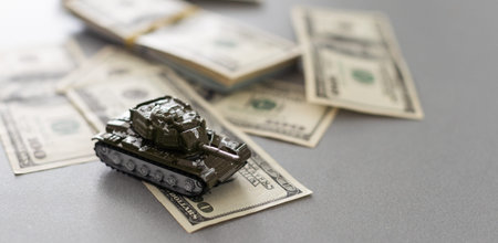Tank on dollar bills. The concept of war costs, military spending.