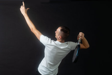 one caucasian mature man Paddle Padel tennis player shadow silhouette in studio isolated on black...