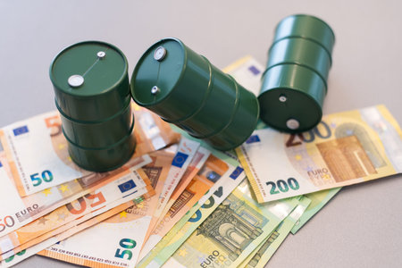 oil barrel with money, euro banknotes closeup