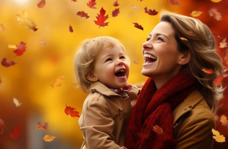 Mother with little son sitting in a autumn fieldの素材