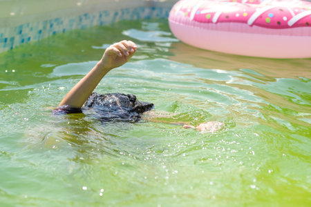 little girl in the green water of very dirty pool