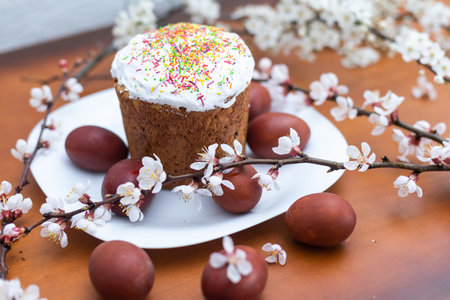 Easter cake, painted egg and blooming branch, spring composition on wooden table