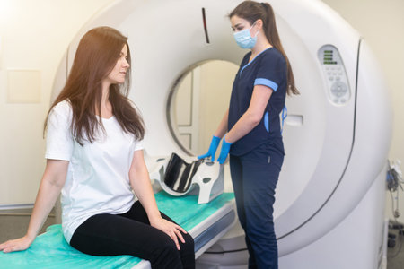 Radiologist with a female patient in the room of computed tomography