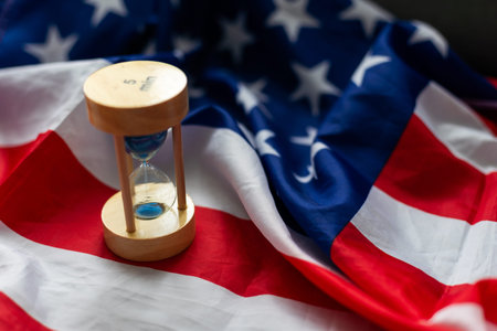 Hourglass and USA flag, soft focus, copy spaceの写真素材