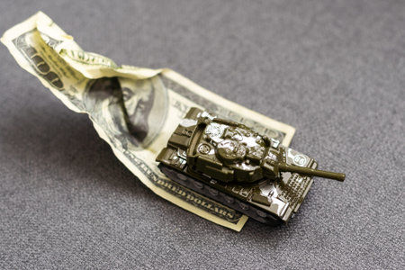 Tank on dollar banknotes. The concept of war costs, military spending, economic crisis