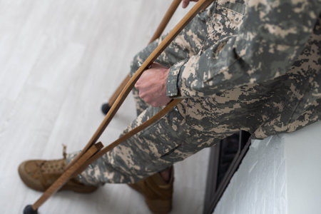 soldier in khaki military uniform on crutches