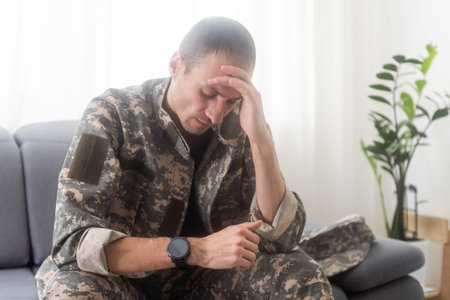 Nervous male military suffering depression, sitting alone at home, PTSD concept