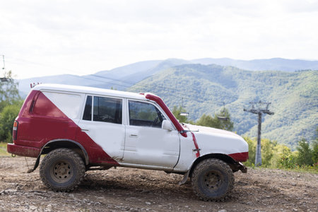 Old four-wheel drive vehicles driving on rocky mountain road on background volcanic landscape