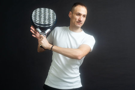 Padel Tennis Player with Racket in Hands. Paddle tennis, on a black background.の写真素材