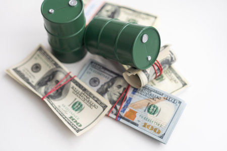 barrels of oil standing on the dollar bills of money. the oil business, purchase sale, production, exchange, trading income.の写真素材