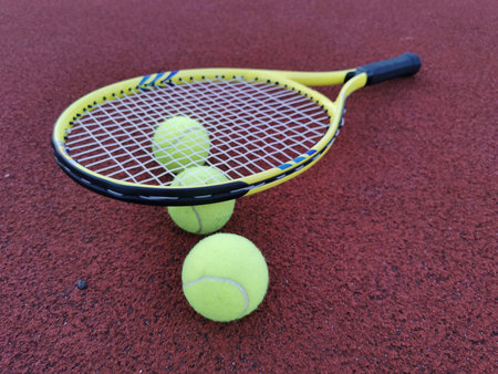 Tennis racket and ball on a hard tennis court