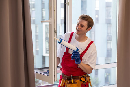 A repairman fixing windows in new apartment.