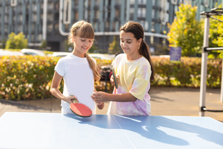 Kid playing table tennis outdoor with familyの写真素材