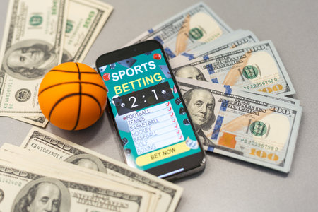 Smartphone with gambling mobile application and basketball ball with money close-up. Sport and betting conceptの写真素材