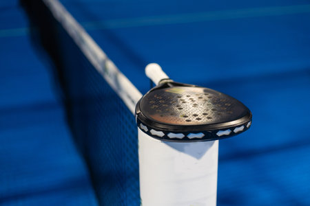 Paddle tennis: Paddel racket and ball in front of an outdoor courtの写真素材