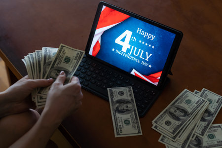 woman holding dollar money and usa flag on tabletの写真素材
