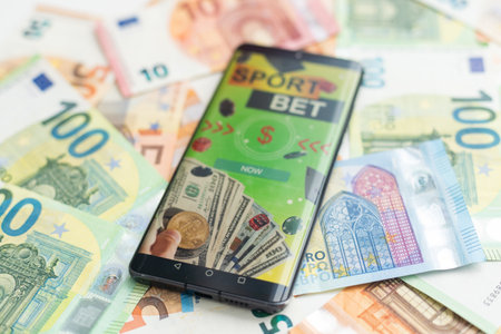 Sports betting website in a mobile phone screen, money. High quality photoの写真素材