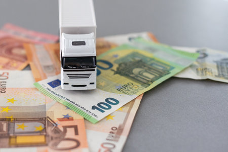 white toy truck on euro banknotes. concept for logistics, transportation and and finance. High quality photoの写真素材