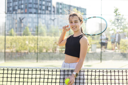 teenage tennis player woman on court with racketの写真素材