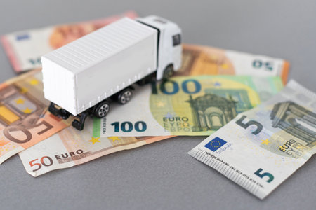 white toy truck on euro banknotes. concept for logistics, transportation and and financeの写真素材
