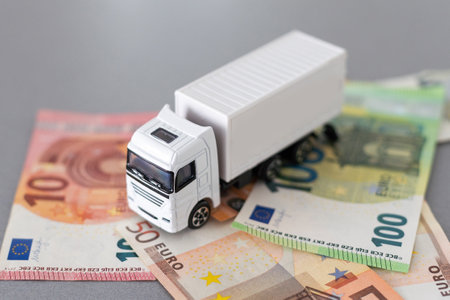 white toy truck on euro banknotes. concept for logistics, transportation and and financeの写真素材