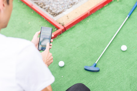 Touch screen in hand, tablet on golf club. smartphone with a sports betting applicationの写真素材
