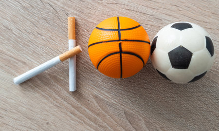 Smoking or sports. Sport ball and pack of cigarettes on table background. Top viewの写真素材
