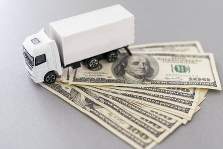 White toy truck lie on dollars, space for text.の写真素材