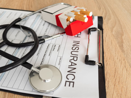 Cigarettes and stethoscope on insurance documentsの写真素材