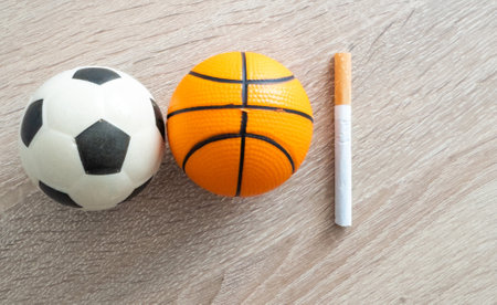 Smoking or sports. Sport ball and pack of cigarettes on table background. Top viewの写真素材
