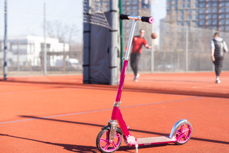 A small kids scooter stands on the sidewalkの写真素材