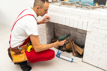 Service technician repairing a fireplace in a homeの写真素材
