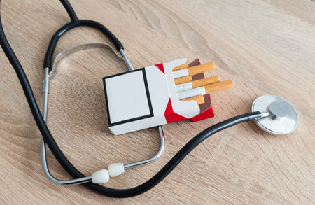 Cigarettes and stethoscope on insurance documentsの写真素材