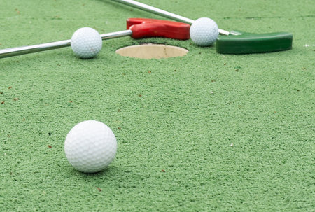 Mini golf close-up, colorful golf putters, balls