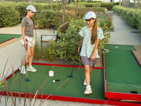 cute little girl on a miniature golf courseの写真素材